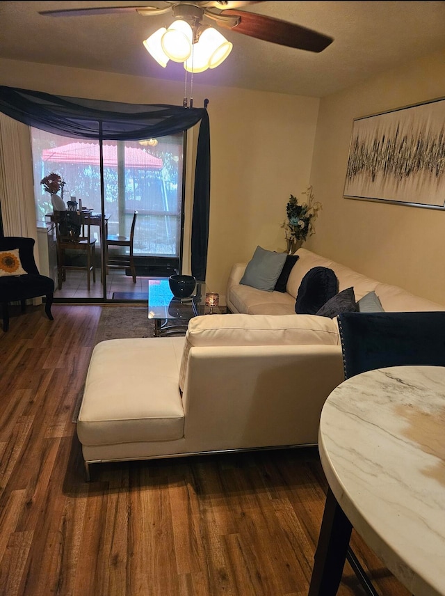 living room with dark wood-type flooring and ceiling fan