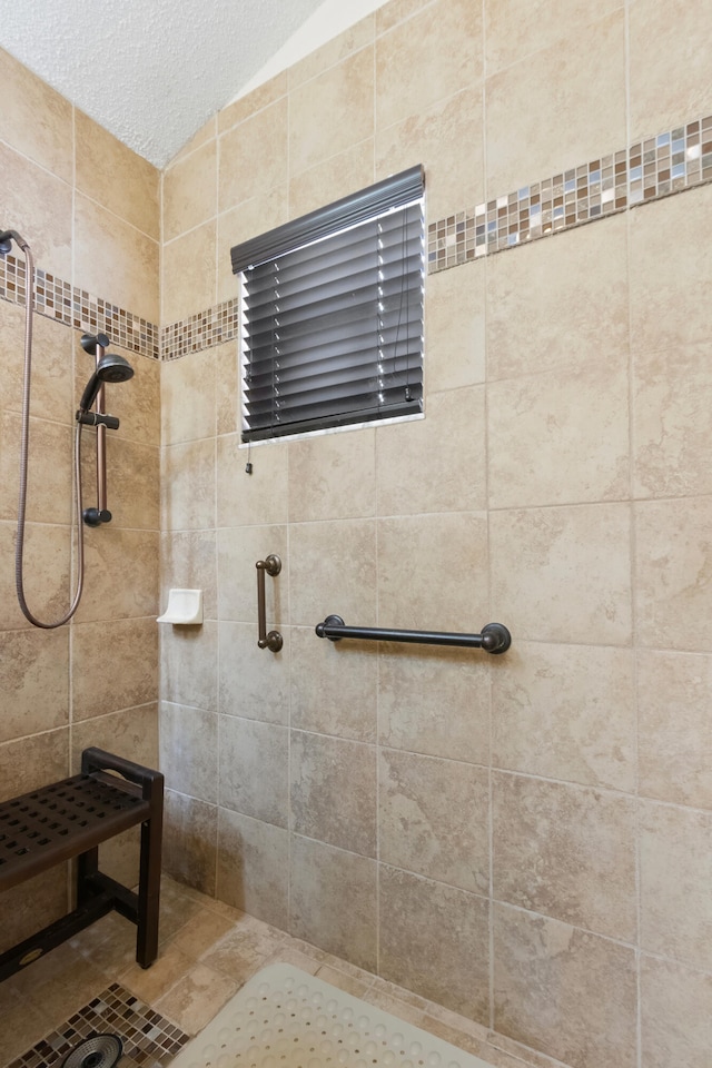 bathroom featuring a tile shower and a textured ceiling