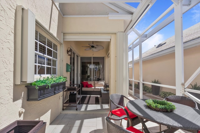 sunroom / solarium with a wealth of natural light, beamed ceiling, and ceiling fan