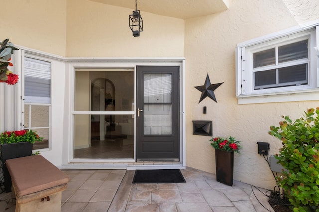 view of exterior entry with a patio