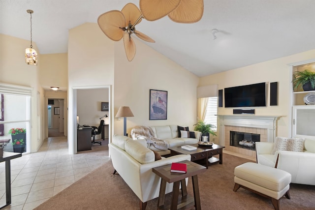 living room with a tile fireplace, light tile patterned floors, high vaulted ceiling, and ceiling fan