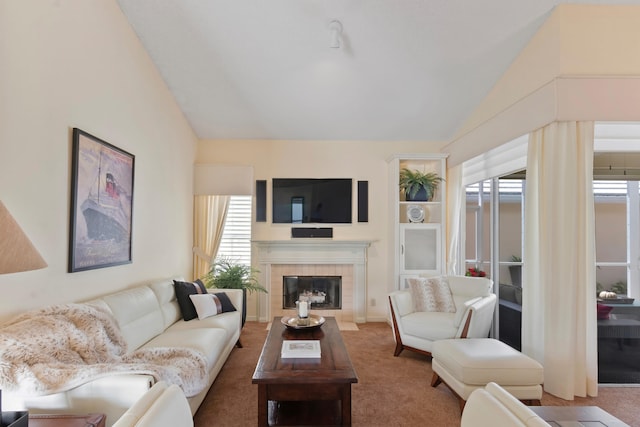 carpeted living room with a tile fireplace and lofted ceiling