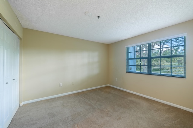 carpeted spare room with a textured ceiling