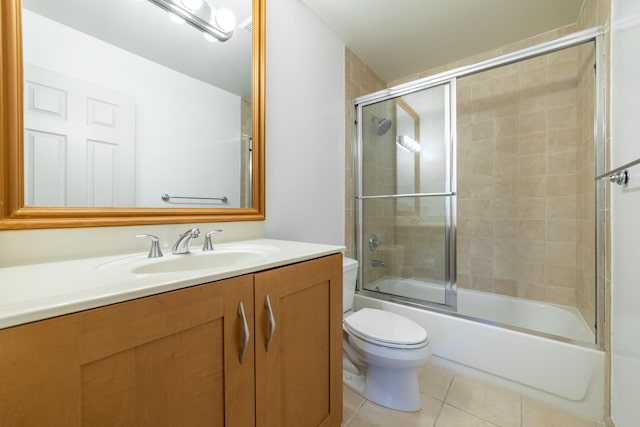 full bathroom featuring enclosed tub / shower combo, tile patterned flooring, vanity, and toilet