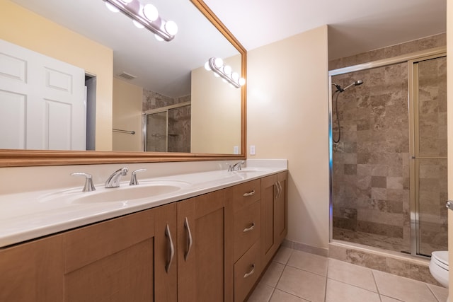 bathroom with vanity, tile patterned flooring, toilet, and a shower with door