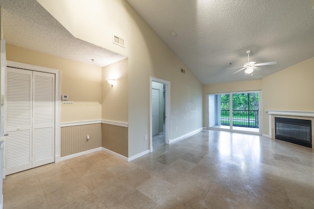 unfurnished living room featuring a textured ceiling, ceiling fan, and high vaulted ceiling