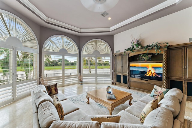 living room with a tray ceiling, ceiling fan, and ornamental molding