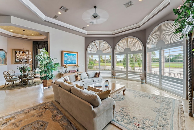 living room featuring a tray ceiling, ceiling fan with notable chandelier, and ornamental molding