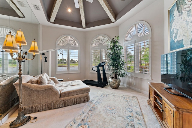 living room featuring light carpet, a high ceiling, a chandelier, and a healthy amount of sunlight