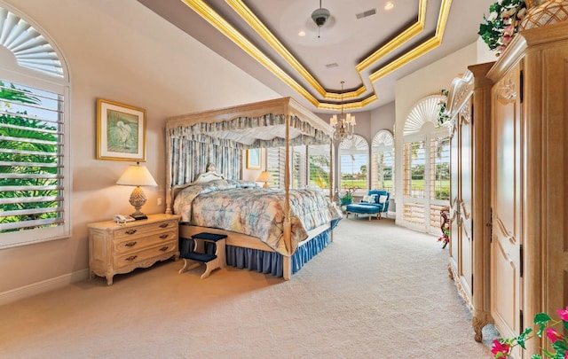 bedroom with light carpet, ceiling fan with notable chandelier, access to outside, a tray ceiling, and crown molding