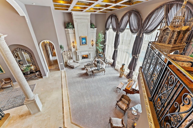 living room with ornate columns, beamed ceiling, and coffered ceiling