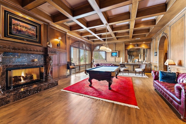 rec room with wooden walls, pool table, a high end fireplace, and ornamental molding