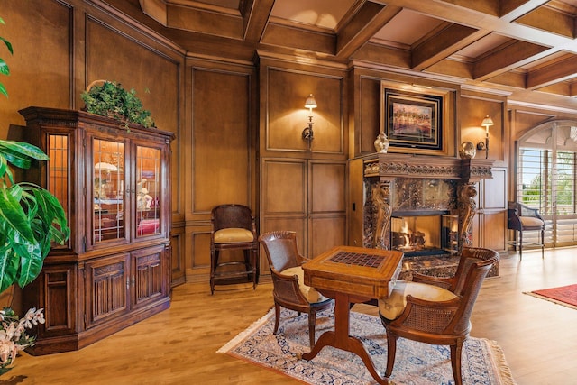 sitting room featuring beam ceiling, coffered ceiling, wood walls, a fireplace, and ornamental molding