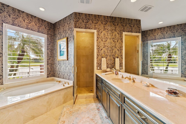 bathroom featuring vanity and independent shower and bath