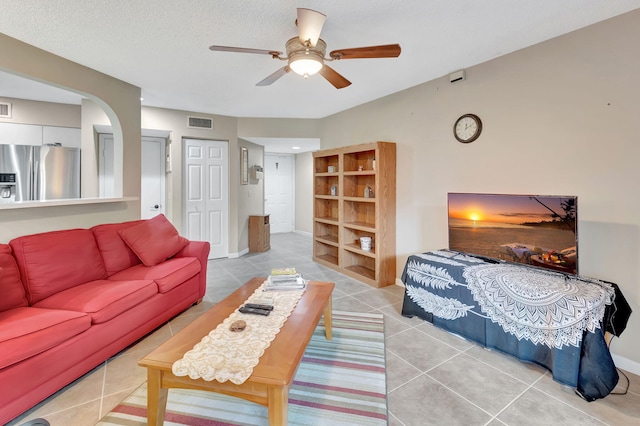 living room featuring a textured ceiling, tile patterned flooring, and ceiling fan