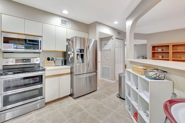 kitchen with white cabinets, appliances with stainless steel finishes, and light tile patterned floors