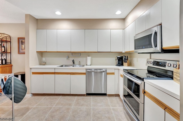 kitchen with appliances with stainless steel finishes, sink, and white cabinets