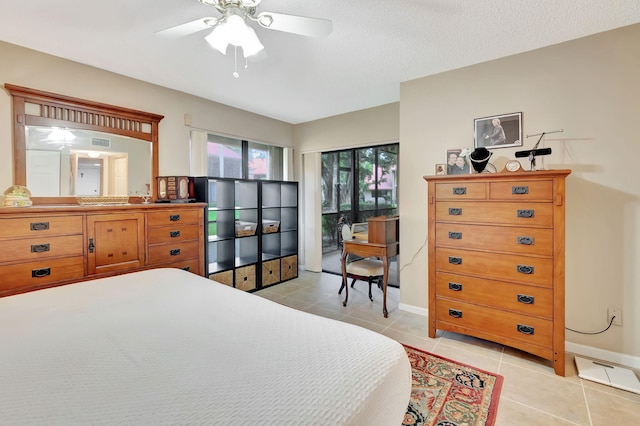 bedroom featuring ceiling fan, light tile patterned floors, and a textured ceiling