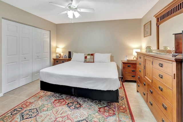 tiled bedroom with ceiling fan and a closet