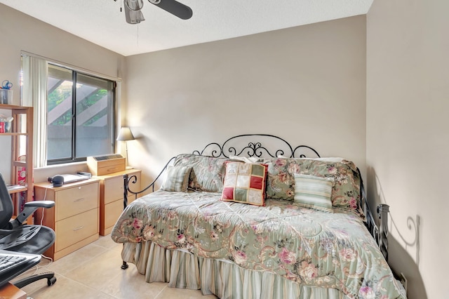 bedroom featuring ceiling fan, a textured ceiling, and light tile patterned floors