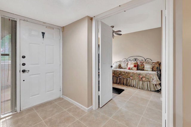 foyer entrance with ceiling fan and light tile patterned floors