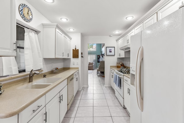 kitchen with white cabinetry, sink, white appliances, and light tile patterned floors