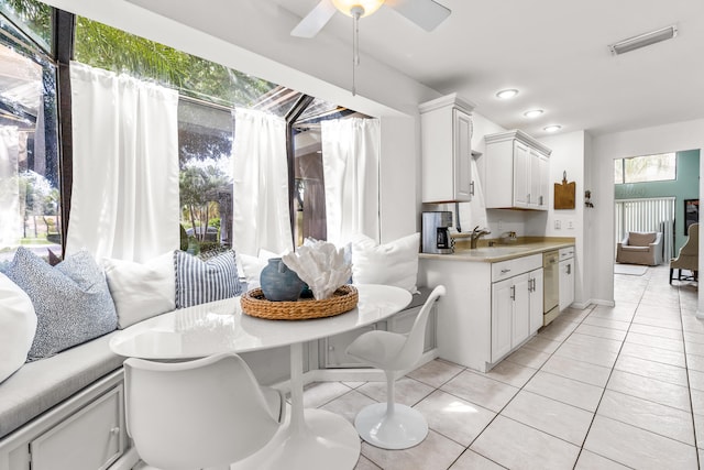 kitchen featuring white cabinets, sink, dishwasher, and light tile patterned floors