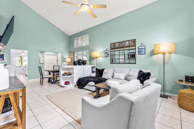 living room featuring a high ceiling, light tile patterned floors, and ceiling fan