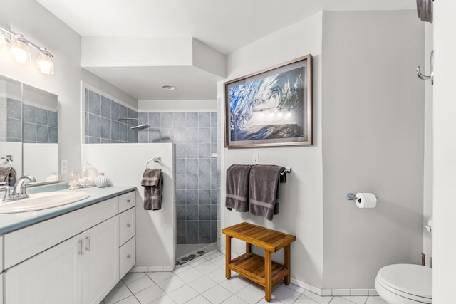 bathroom with vanity, tile patterned flooring, and tiled shower