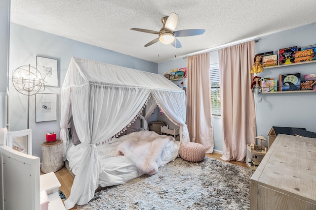 bedroom with ceiling fan, a textured ceiling, and wood-type flooring