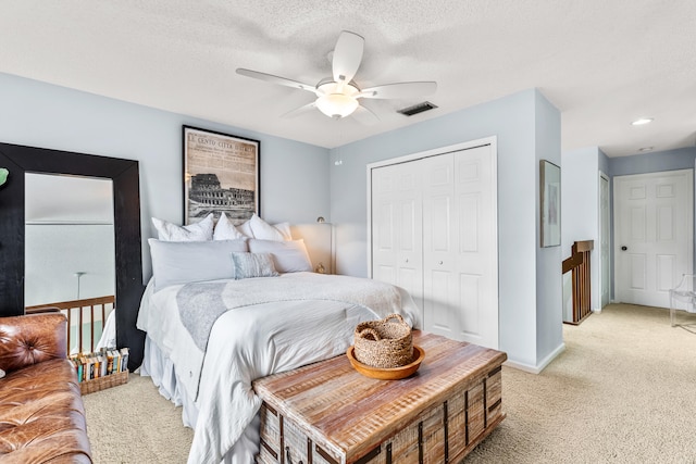 carpeted bedroom featuring a textured ceiling and ceiling fan