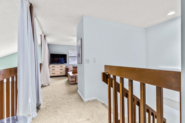 hallway featuring carpet floors and a textured ceiling