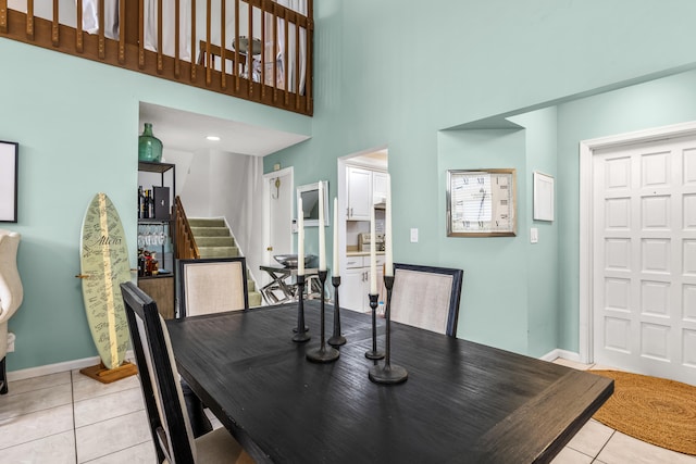 tiled dining area featuring a high ceiling