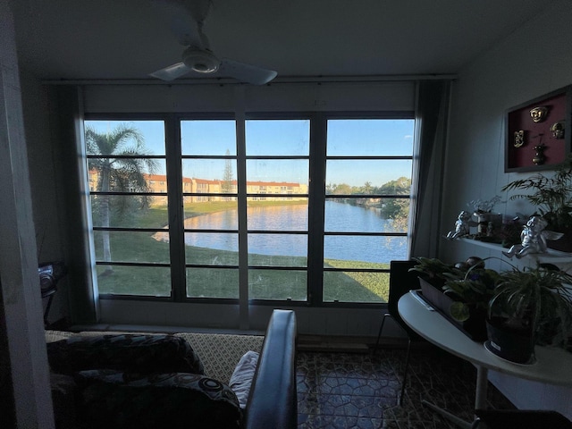 interior space with ceiling fan, a water view, and a healthy amount of sunlight