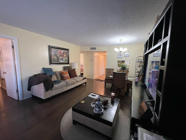 living room featuring a textured ceiling, dark hardwood / wood-style flooring, and a notable chandelier