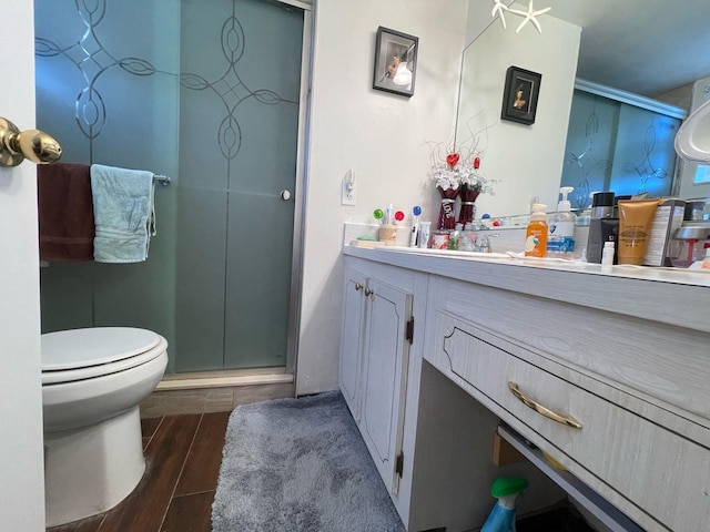 bathroom featuring wood-type flooring, vanity, toilet, and an enclosed shower