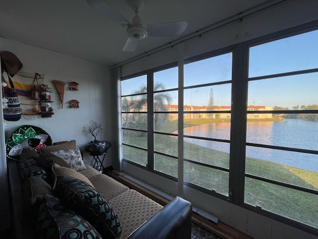 sunroom with a water view and ceiling fan