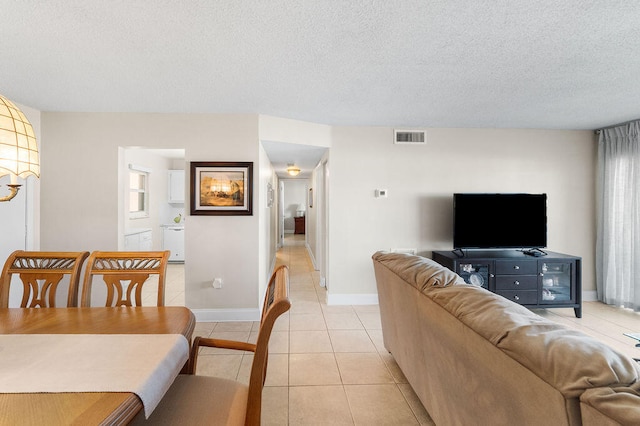 living room with a textured ceiling and light tile patterned flooring