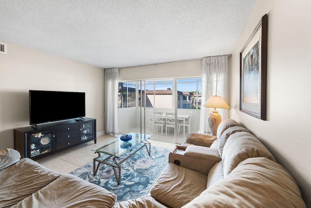 tiled living room featuring a textured ceiling