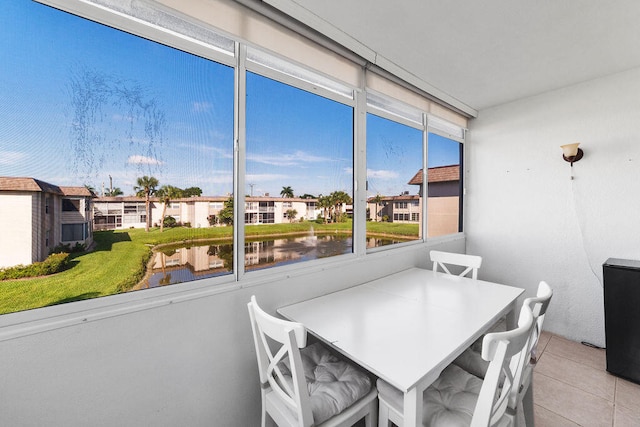 sunroom featuring a water view