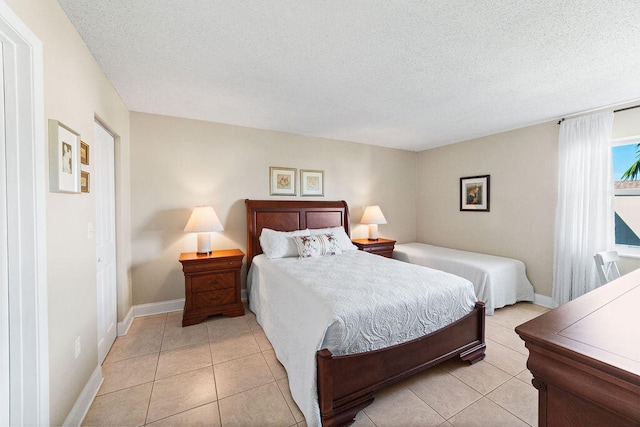 bedroom with a textured ceiling and light tile patterned floors