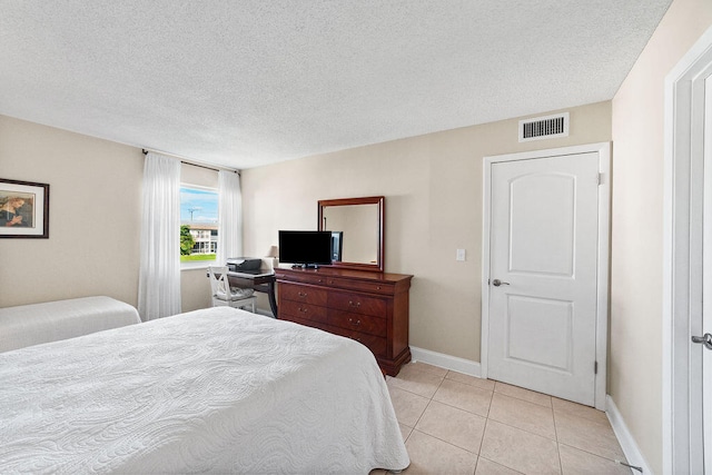 tiled bedroom featuring a textured ceiling