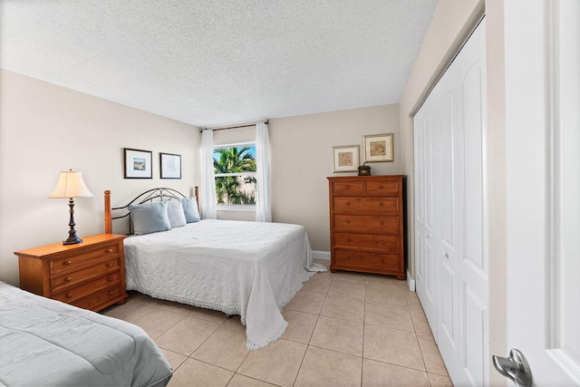 tiled bedroom with a closet and a textured ceiling