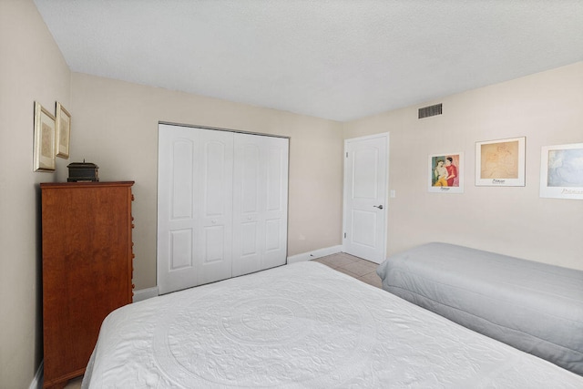 tiled bedroom with a closet