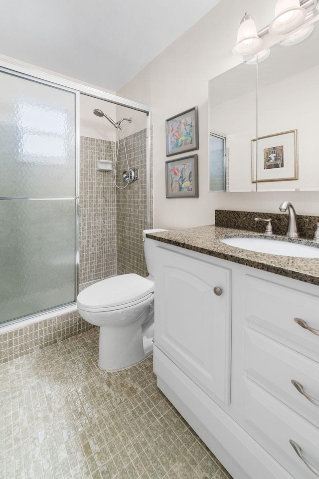 bathroom featuring vanity, tile patterned flooring, toilet, and a shower with door