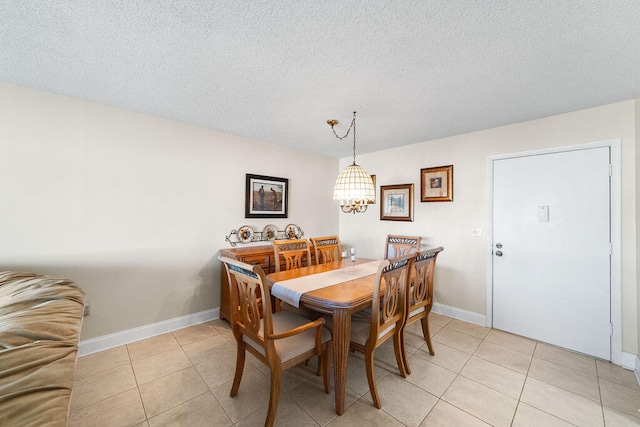 tiled dining space with a textured ceiling