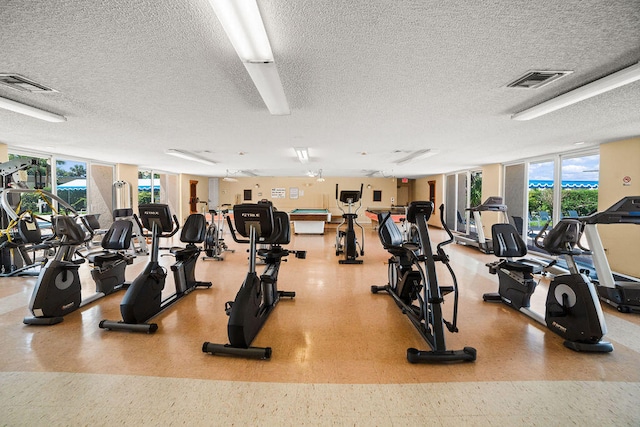 exercise room with a textured ceiling and floor to ceiling windows