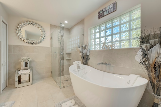 bathroom with plus walk in shower, tile patterned flooring, and tile walls