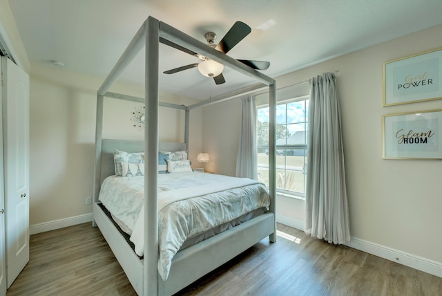 bedroom with ceiling fan, light hardwood / wood-style flooring, and a closet