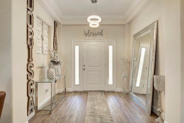 entrance foyer featuring ornamental molding and hardwood / wood-style floors